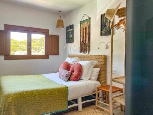 Un dormitorio con una cama con almohadas. en Hostal Mar y Sal, en Sant Josep de sa Talaia