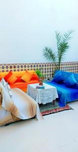 un sofá con almohadas coloridas y una mesa en Riad Diafa en Rabat