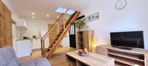 a living room with a television and a staircase at Apartamenty Poddąbie1 in Poddąbie