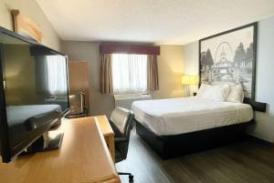 una camera d'albergo con letto e scrivania di Super 8 by Wyndham St. Clair MO a Saint Clair