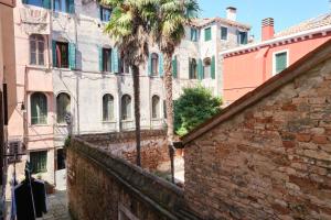 un callejón con una palmera y edificios en Lustraferi Apartment, en Venecia