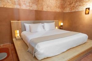 a bedroom with a large bed with white pillows at Jr-Kiyo Estudios in Oaxaca City