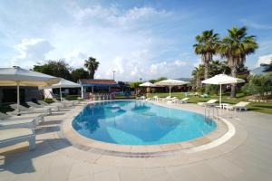 a large swimming pool with chairs and umbrellas at Kasaba Butik Otel in Fethiye