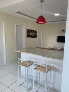 a kitchen with a counter and two stools at Apto Aconchegante - 600m da Pç Mestre Dominguinhos in Garanhuns