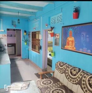 sala de estar con sofá y pared azul en Suraj Guest House, en Varanasi