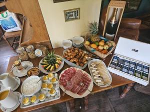 uma mesa com muitos tipos diferentes de alimentos sobre ele em Lodge Hôtel de Sommedieue Verdun em Sommedieue