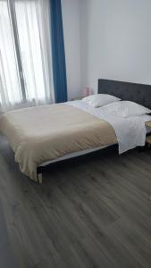 1 cama en un dormitorio con ventana grande en Appartement F3, proche paris en Épinay-sur-Seine