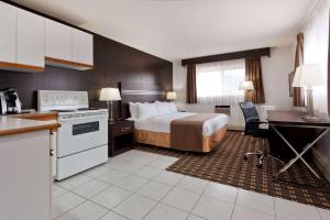 una camera d'albergo con letto e cucina di Super 8 by Wyndham Valemount a Valemount