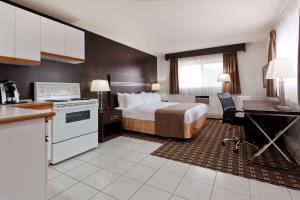 a hotel room with a bed and a kitchen at Super 8 by Wyndham Valemount in Valemount