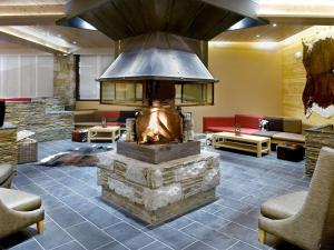 a lobby with a large fireplace in the middle at Mercure Saint-Lary in Saint-Lary-Soulan