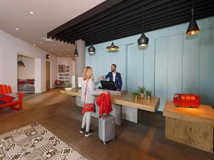 a man and a woman standing at a desk at Ibis El Jadida in El Jadida