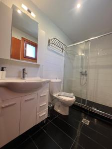 a bathroom with a sink and a toilet and a shower at Panos Villas in Koukounaries