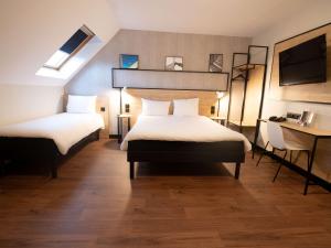Habitación de hotel con 2 camas y escritorio en ibis Creil Sur Oise, en Villers-Saint-Paul