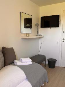 RødvigにあるMunkgaard Bed & Breakfastのベッド、鏡、椅子が備わる客室です。