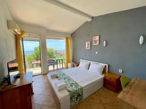 1 dormitorio con 1 cama grande y balcón en Guesthouse Serenity hill, en Sveti Vlas