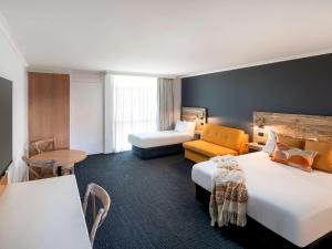 pokój hotelowy z 2 łóżkami i kanapą w obiekcie ibis Styles Orange w mieście Orange