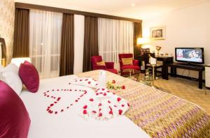 a hotel room with a bed with a flower on it at The Panari Hotel - Near Jomo Kenyatta International Airport in Nairobi