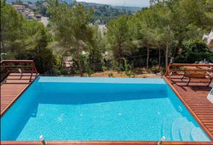 a blue swimming pool with a view of trees at Casa Majestic in Cunit