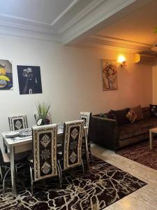 - un salon avec une table, des chaises et un canapé dans l'établissement Beautiful apartment in the city center, à Casablanca