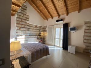 a bedroom with a bed and a stone wall at Ca' San Sebastiano Wine Resort & Spa in Camino