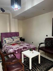 カサブランカにあるBeautiful apartment in the city centerのベッドルーム(紫色のベッド1台、テーブル付)