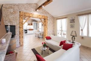 a living room with white furniture and a brick wall at Villetta tra Mari e Monti by BarbarHouse in San Giovanni Rotondo