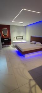 a room with two beds and a tub with blue lights at Motel Monza (Adult Only) in Santos