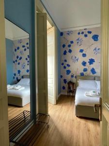 a bedroom with two beds and blue flowers on the wall at Casa Flos31 in Catania