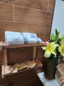 un estante de madera con una toalla y un jarrón de flores en Ngũ Chỉ Sơn Trekking Sapa en Sa Pa