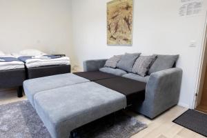 a living room with a couch and a bed at Keskusta sviitti parvekkeella ja pyykinpesukoneella Vanha Postitalo in Varkaus