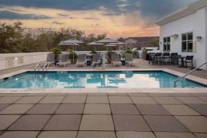 a swimming pool with chairs and tables on a building at Hilton Garden Inn Charleston / Mt. Pleasant in Charleston