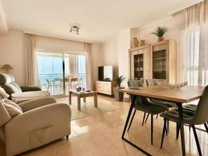 a living room with a table and a couch and a dining room at Porto Azul 10A Frontal Peñon & Sea View First Line Arenal Beach in Calpe