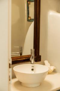 un lavandino bianco in un bagno con specchio di Honey Bee House a Mykonos Città