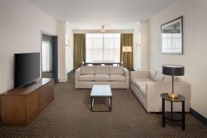 a living room with a couch and a flat screen tv at DoubleTree Suites by Hilton Lexington in Lexington
