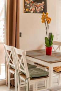 un tavolo da pranzo con due sedie e un vaso con una pianta di Honey Bee House a Mykonos Città
