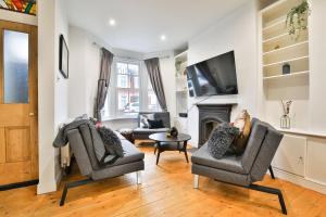 a living room with two chairs and a fireplace at StayRight 3-Bed Pontcanna House Next to Pontcanna Fields in Cardiff