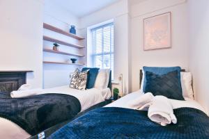 two beds in a room with a fireplace at StayRight 3-Bed Pontcanna House Next to Pontcanna Fields in Cardiff