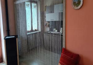 a glass shower in a room with a red pillow at La Magnolia B&B in Gassino Torinese