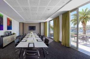 una sala de conferencias con una mesa larga y sillas en Crown Promenade Perth, en Perth