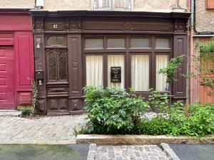 une maison avec une porte en bois et une porte rouge dans l'établissement Epicerie Vieille du Puy en Velay, au Puy-en-Velay