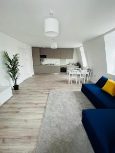 濱海紹森德的住宿－Stunning New Penthouse Apartment，一间带蓝色沙发的客厅和一间厨房
