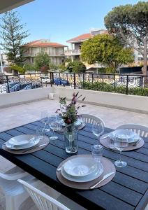 a table with glasses and plates and flowers on it at Poetto Beach House - Molara1 in Cagliari