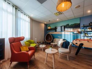 - une salle d'attente avec un billard et des chaises dans l'établissement ibis Styles Ancenis Centre, à Ancenis