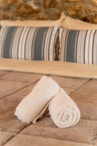 a white towel laying on the floor next to a bed at Honey Bee House in Mýkonos City