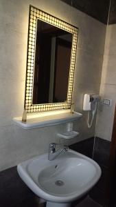 La salle de bains est pourvue d'un lavabo et d'un miroir. dans l'établissement YOYA pyramids KINGDOM view, au Caire