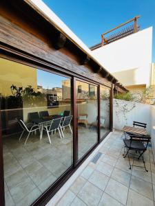 eine Terrasse mit Glastüren und einem Tisch und Stühlen in der Unterkunft Sicilia Vacation in San Vito lo Capo