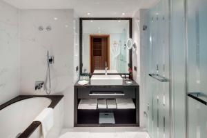 a bathroom with a tub and a sink and a bath tub at Kempinski Hotel Corvinus Budapest in Budapest
