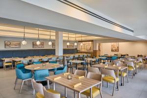 博伟公园Doubletree by Hilton Buena Park的一间有桌椅的大餐厅