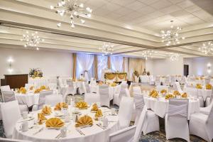 a banquet hall with white tables and chairs and chandeliers at Doubletree by Hilton Buena Park in Buena Park +71 photos