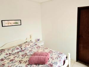 una camera da letto con un letto e un asciugamano rosa di Flor de Lótus Suites a Tamandaré